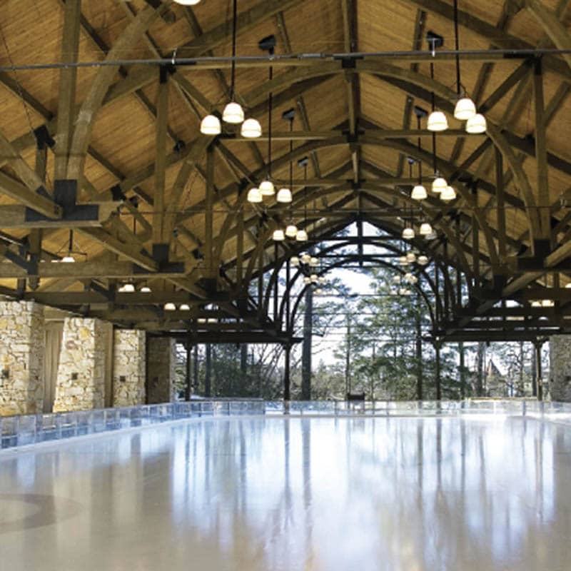 Partially indoor ice skating rink with high ceilings and wooden beams