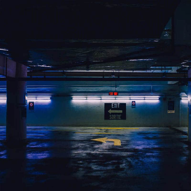 A dimly lit high tech parking garage