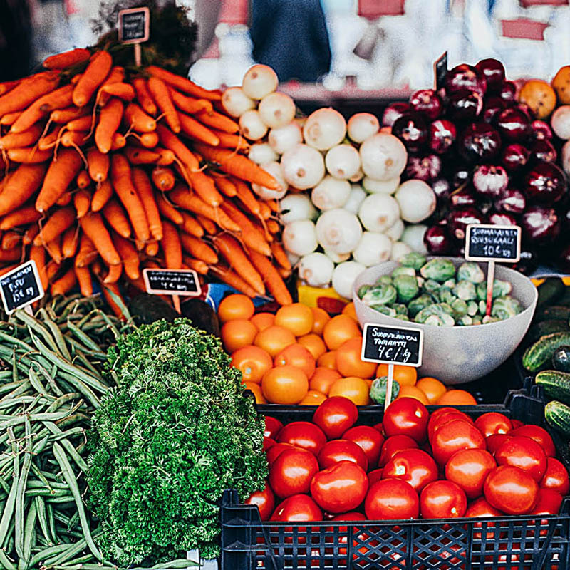 Vibrant, colorful fresh vegetables piled on a table at a farmers' market